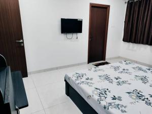 a room with a bed and a tv on the wall at Skyline View Suite in Hyderabad