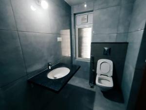 a bathroom with a sink and a toilet and a window at Skyline View Suite in Hyderabad