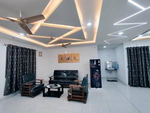 a living room with a couch and chairs and a ceiling at Skyline View Suite in Hyderabad