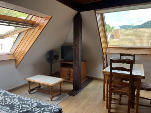 a room with a table and a tv and two windows at Home sweet home in La Bresse