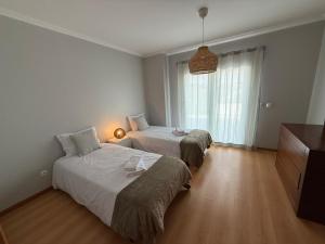 Un dormitorio con dos camas y una ventana. en Casa de Férias Lucena, en Lourinhã