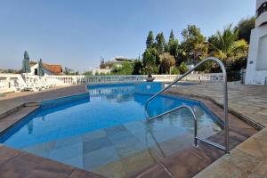 a swimming pool with a metal hand rail next to a building at Piemonte Flat Apart in Serra Negra