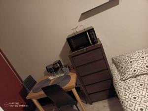 a bedroom with a table with a microwave and a bed at NOCLEGI Marek - Darłowo Centrum in Darłowo