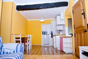 ポラ・デ・レナにあるLa casa'l cantirínの黄色の壁のキッチン(テーブル、椅子付)