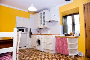 ポラ・デ・レナにあるLa casa'l cantirínのキッチン(白いキャビネット、洗濯機、乾燥機付)