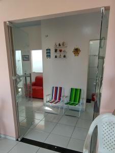a living room with two chairs and a mirror at Casa Recanto das Flores in Barreirinhas