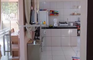 a kitchen with white cabinets and a refrigerator at Casa Recanto das Flores in Barreirinhas