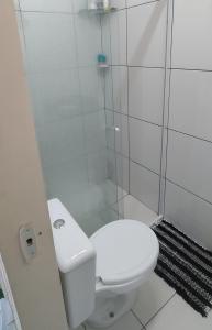 a white bathroom with a toilet and a shower at Casa Recanto das Flores in Barreirinhas