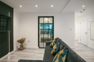a living room with a couch and a window at Town Centre apartment with private patio - Near Airport & Train Station in Luton