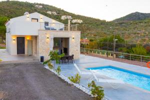 a villa with a swimming pool and a house at Pierres Blanches Residences, with private pools in Mytilene