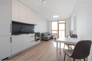 a kitchen and living room with a table and chairs at Two room Apartment - self check-in in Vilnius