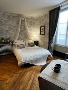 a bedroom with two beds and a window at La Demeure d'Euphrosine in Fresnay-sur-Sarthe