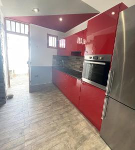 een keuken met rode kasten en een koelkast bij Duplex Holidays Beach in San Bartolomé