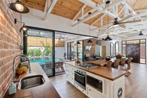 an open kitchen with a pool in the background at Swim-Through Glass Pool Villa, 5min Beach in Playa Flamingo +11 photos