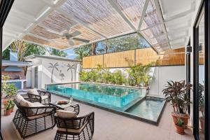 an indoor swimming pool with chairs and a table at Swim-Through Glass Pool Villa, 5min Beach in Playa Flamingo