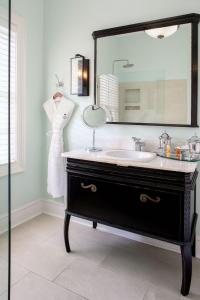 a bathroom with a sink and a large mirror at The Gardens Hotel in Key West