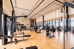 a gym with treadmills and people exercising in it at Mossaz Mana-Mana Suites Kuala Lumpur in Kuala Lumpur