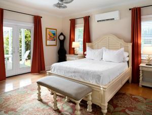 a bedroom with a white bed and red curtains at The Gardens Hotel in Key West