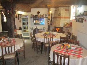 a dining room with two tables and a fireplace at Guest House Popov in Marchevo