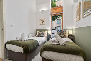 a bedroom with two beds and a window at Sleek Modern City Apartment in Milton Keynes