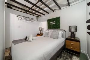 a bedroom with a white bed and a green painting on the wall at Chic & Cozy Loft near Rogers Place, LRT, Jasper Ave in Edmonton