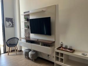 a living room with a flat screen tv on a wall at Tasbi House Loft Piratininga in Niterói