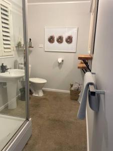 a bathroom with a toilet and a sink at The Barn - Space for Family and Friends in Omaha