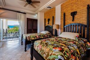a bedroom with two beds and a view of the ocean at Swim-Up Pool Bar, Walk to Beach & Panoramic Views in Tamarindo