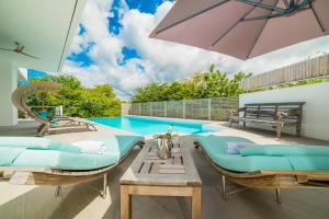a swimming pool with two lounge chairs and an umbrella at Ocotal Luxury Villa with Private Pool in Ocotal +15 photos