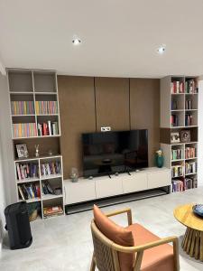 a living room with a television and book shelves at Cetinje Holiday Home for Family in Cetinje