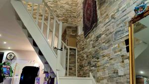 un mur en pierre avec un escalier dans une maison dans l'établissement Chambre meublée dans une maison haut de gamme avec jardin proche métro, à Châtillon