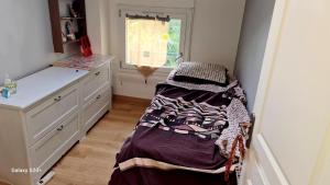 une petite chambre avec un lit et une fenêtre dans l'établissement Chambre meublée dans une maison haut de gamme avec jardin proche métro, à Châtillon