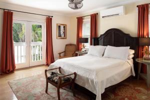 a bedroom with a large bed and a chair at The Gardens Hotel in Key West