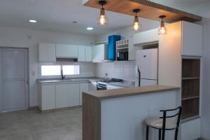 a kitchen with white cabinets and a counter top at Dúplex Nuevo - Salta Capital in Salta +18 photos