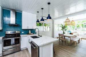 a kitchen with blue and white cabinets and a table at Barefoot Beachfront, Pool, Surf & Private Casita in Playa Grande