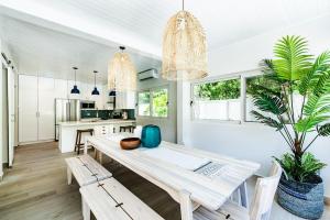 a dining room with a table and chairs and a plant at Barefoot Beachfront, Pool, Surf & Private Casita in Playa Grande