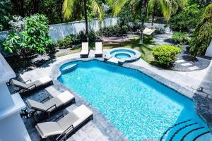 an overhead view of a swimming pool with chaise lounge chairs and a swimming pool at Barefoot Beachfront, Pool, Surf & Private Casita in Playa Grande