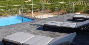 a patio with two beds and a swimming pool at Huerto del Medico in Reig