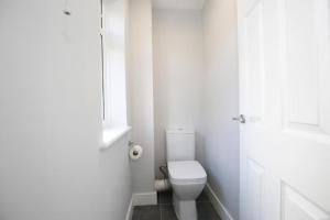 Yarntonにある3 BR Begbroke House Oxfordのトイレと窓のある白いバスルーム