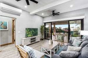 a living room with a couch and a tv at Charming 2BR - 2BA Condo Steps to the Beach in Tamarindo