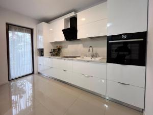 a kitchen with white cabinets and a sink and a window at Casa dulce casa in Dumbrăviţa