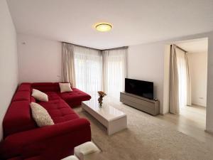a living room with a red couch and a tv at Casa dulce casa in Dumbrăviţa