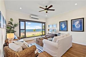 a living room with white furniture and a view of the ocean at Picturesque Beachfront Condo w - Pool in Playa Flamingo