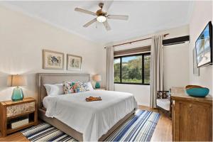 a bedroom with a bed and a ceiling fan at Picturesque Beachfront Condo w - Pool in Playa Flamingo