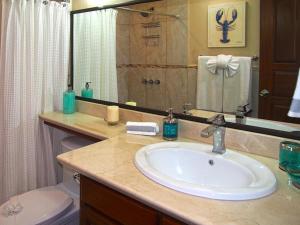 a bathroom with a sink and a toilet and a mirror at Picturesque Beachfront Condo w - Pool in Playa Flamingo +11 photos