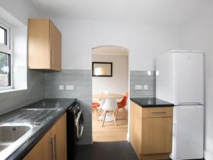 Yarntonにある3 BR Begbroke House Oxfordの白い冷蔵庫とテーブルのあるキッチン +2枚の写真