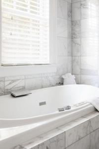 a white bath tub in a bathroom with a window at The Gardens Hotel in Key West