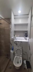 a bathroom with a white toilet in a room at ZONA apartman in Vranje +11 photos