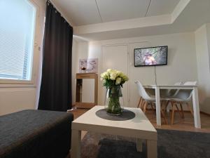 a room with a vase of flowers on a table at Lovely 2R apartment, parking in Oulu