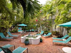 a patio with chairs and a table with a fountain at The Gardens Hotel in Key West